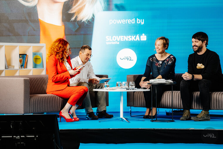 Diskusia na konferencii s tromi mužmi a jednou ženou na pódiu s modrým pozadím a logom Slovenská sporiteľňa