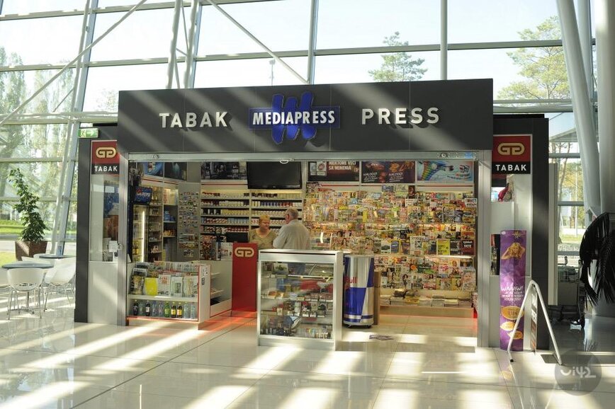 Novinový stánok s nápisom Tabak a Mediapress vo vnútri modernej budovy